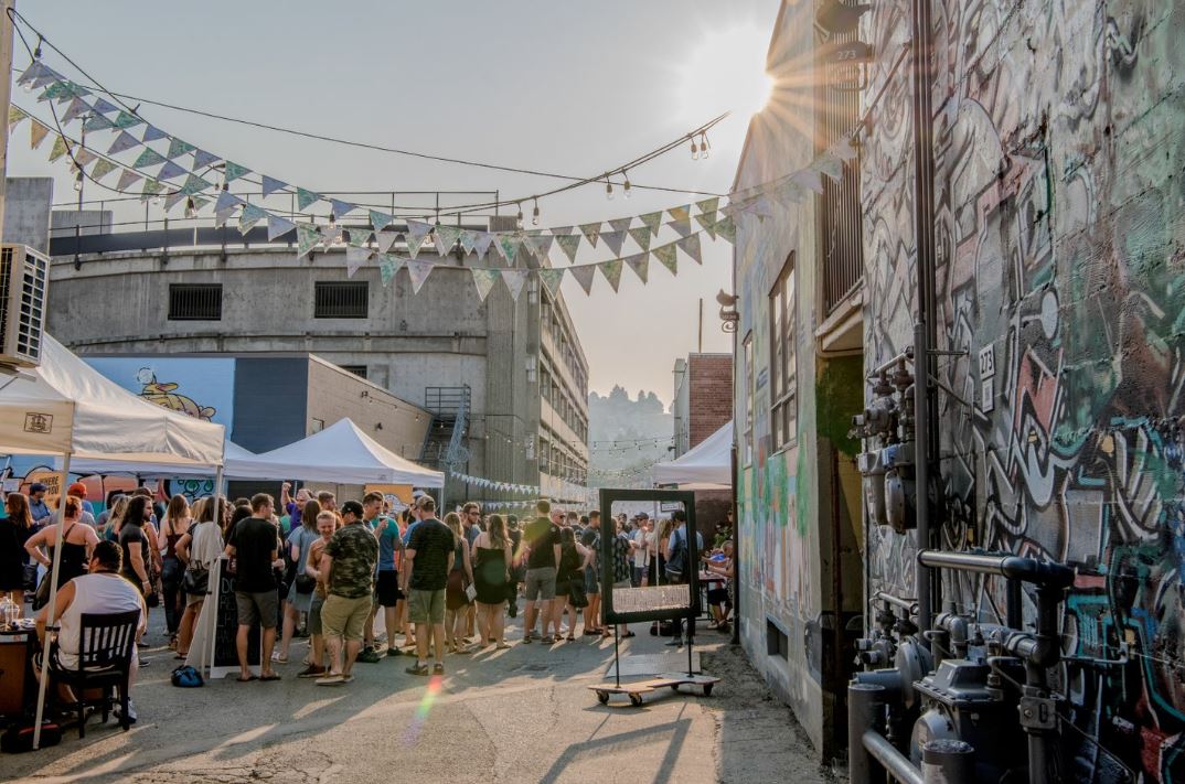 A crowd of people enjoying a back alley party in Kamloops, when the sun is shining. 